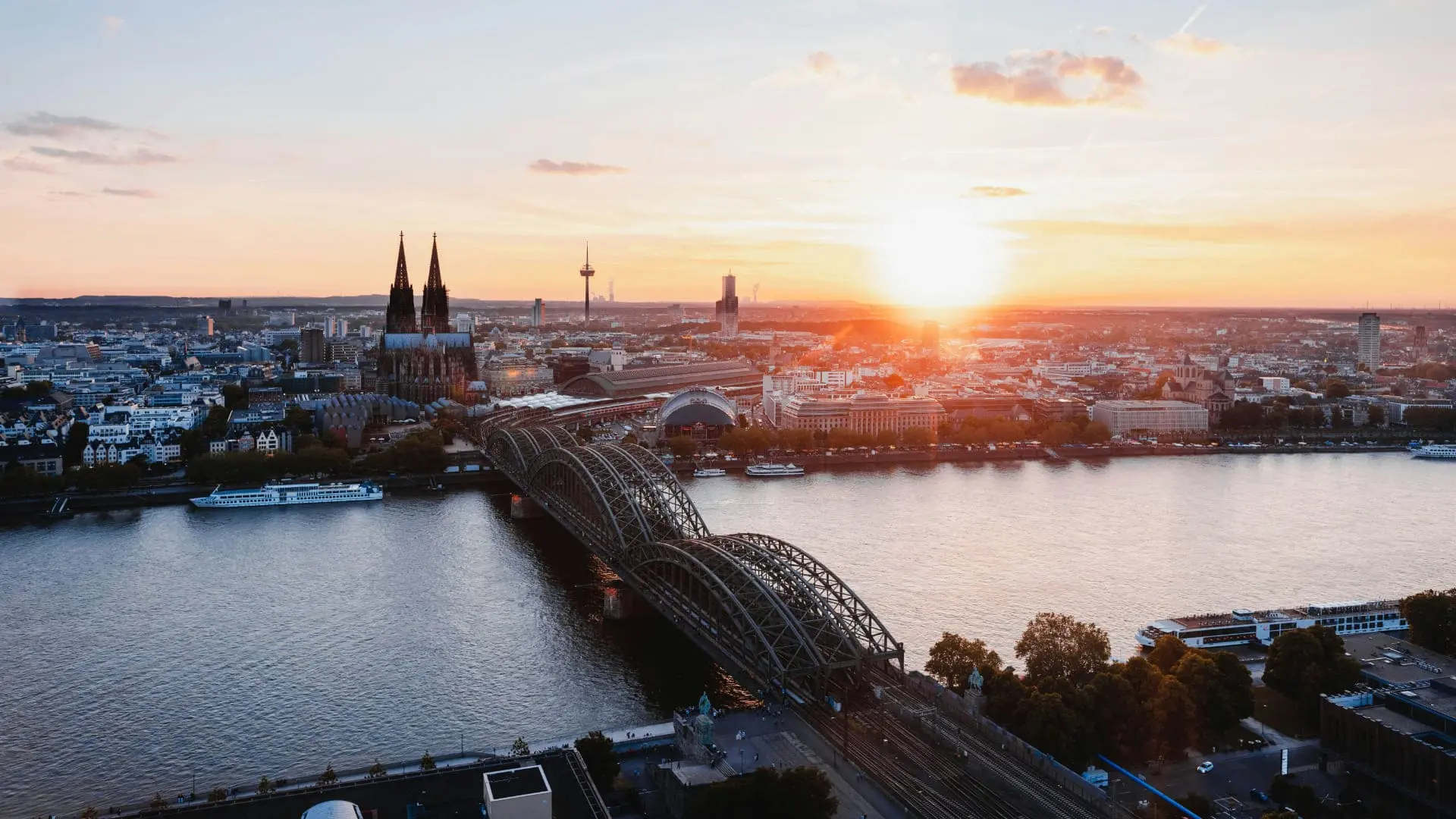 Das Bild zeigt die Skyline von Köln beim Sonnenuntergang mit Blick auf den Kölner Dom